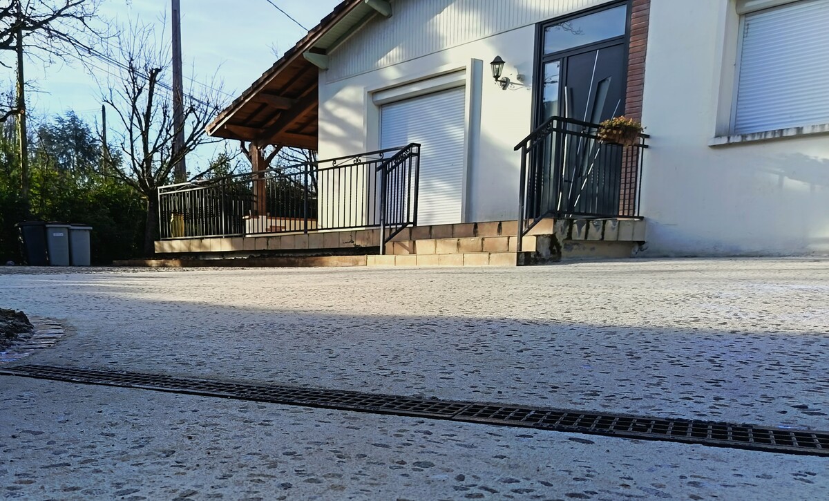 Réalisation du parking en béton désactivé de chez Lafarge -ciment blanc -galets de Garonne roulés 10/20 et finition bouchardée. Mise en œuvre de caniveaux grille fonte relié au pluvial existant.