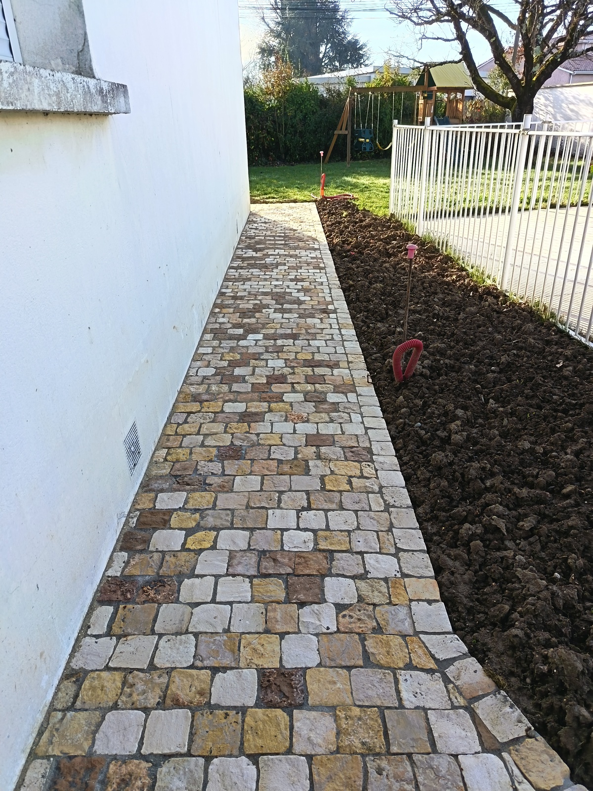 Réalisation du tour de maison en pavés de Tunisie calcaire beige- 10x10cm-épais 4 à 6cm - Pose sur grave ciment , chape et joints ciment, pose alignée.